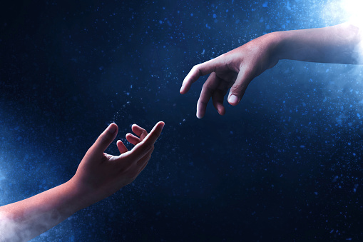 Hands reaching on dark background