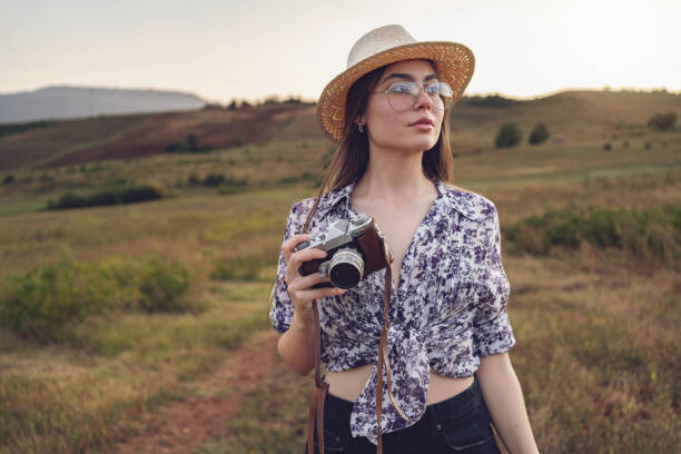 istock Young woman, with retro camera walking through meadow 1419012579