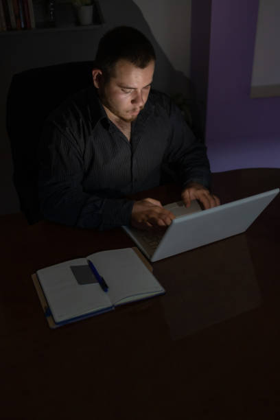 istock Young man at night working on his laptop finishing his work. 1419014254
