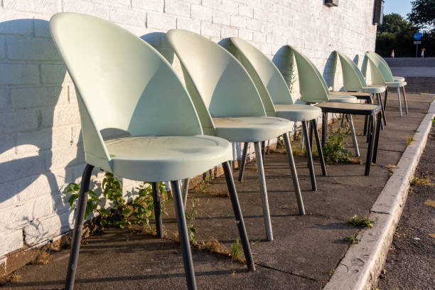 istock Row of empty cheap white plastic chairs for sitting outside 1419016846