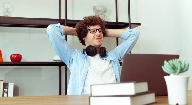 Young Caucasian Man work from home on laptop and connect online to office indoor for remote internet workplace. Young Adult male is freelance work smart on notebook sit in working room, copy space joven caucásico trabaja desde casa en una computadora portátil y se conecta en línea a la oficina en interiores para un lugar de trabajo remoto por internet. el hombre adulto joven es un trabajo independiente inteligente en el cuaderno sentarse en la sa