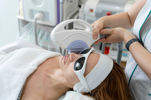 Anti-aging procedures. Skin care concept. Woman receiving laser facial treatment, removing pigmentation at cosmetic clinic. Intense pulsed light therapy. IPL. Rejuvenation, facial phototherapy