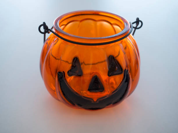 istock glass Tea light jar shaped as orange Halloween Pumpkin on white background 1419021293