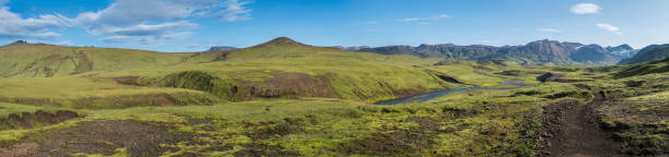 istock Panoramic landscape with blue river stream, green hills, snow-capped mountains, meadow and lush moss. Laugavegur hiking trail. with Fjallabak Nature Reserve, Iceland. Summer blue sky 1419021320