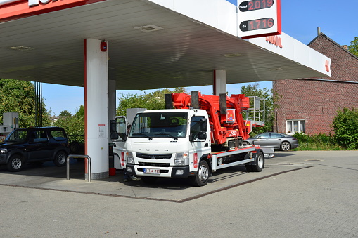 Wilsele, Vlaams-Brabant, Belgium - August, 29, 2022: petrol gas station. Refueling parked Fugo transport  truck with a little excavator on a trailer