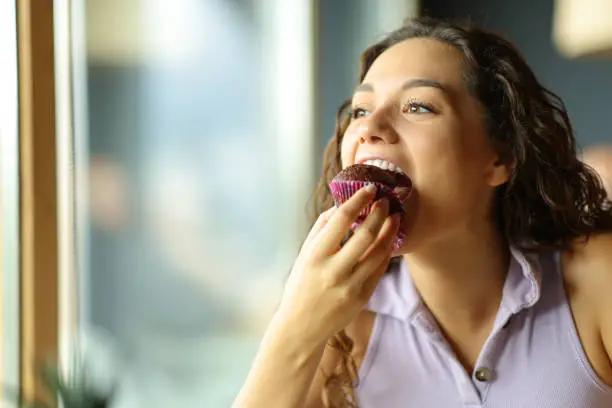 Photo of Woman eating chocolate cupcake in a restaurant