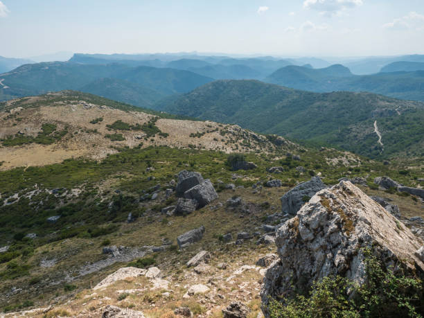 View from white limestone tower Perda Liana, impressive rock boulders, green forest hill and mountain. National Park of Barbagia, Central Sardinia, Italy, summer day.