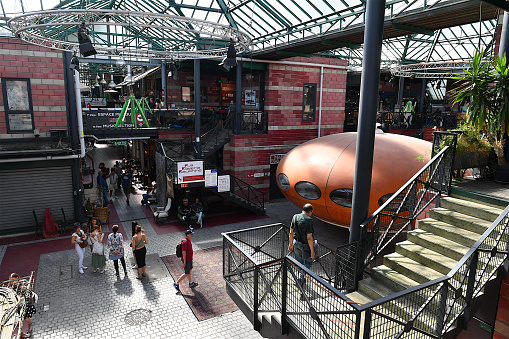 Saint-Ouen, France-08 27 2022: People browsing through the stalls of classic antiques, vintage furniture and fashion, industrial design in the Marché Dauphine, part of the Saint-Ouen flea market in the suburb of Paris, France.