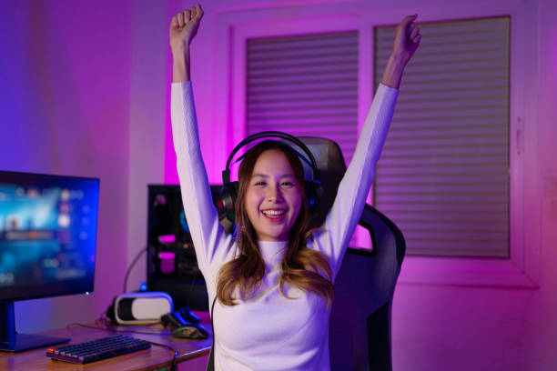istock Asian gamer playing online video game winning excited on PC with lighting effect, broadcast streaming live at home. Gamer and E-Sport online gaming technology Championship tournament gamer concept. 1419031185
