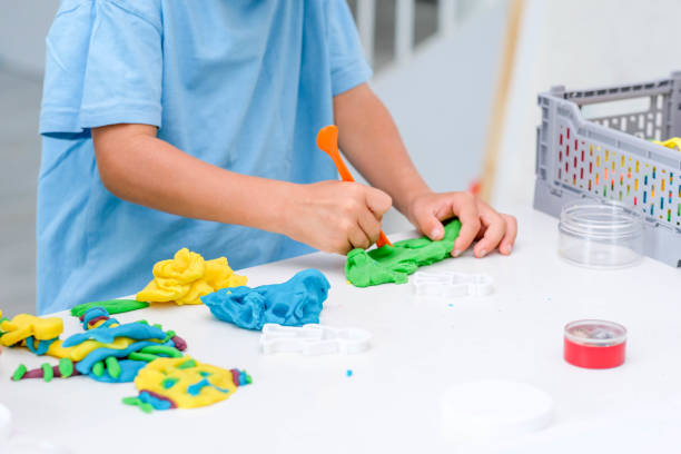 istock Caucasian boy plays with plasticine on table, modeling clay, molds, sculpture. 1419035999