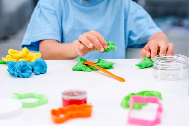 istock Caucasian boy plays with plasticine on table, modeling clay, molds, sculpture. 1419036117