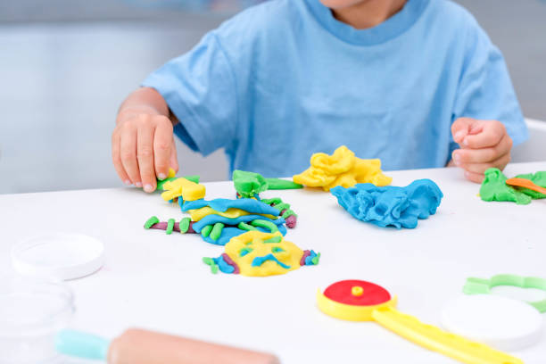 istock Caucasian boy plays with plasticine on table, modeling clay, molds, sculpture. 1419036124