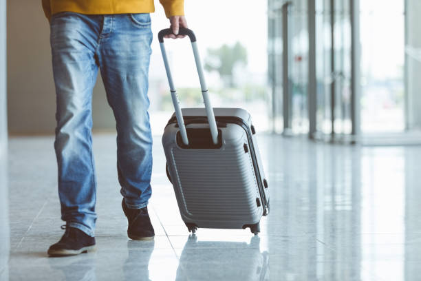istock Man walking with luggage at airport 1419042195