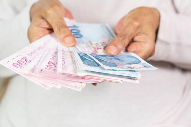 istock old women Hands holding Turkish Lira banknotes 1419043569