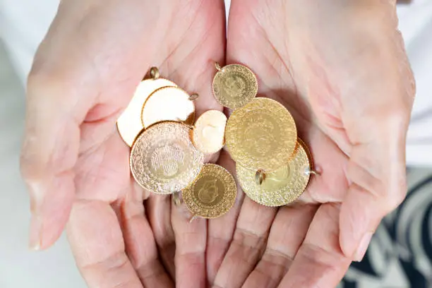 Hand holding Turkish gold coin, Close up