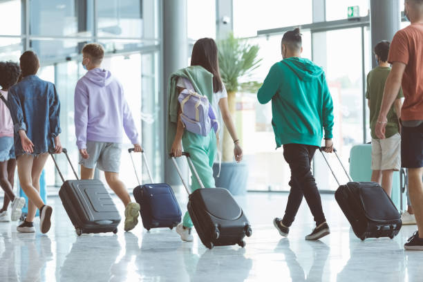 istock Passengers walking with luggage at airport 1419044310