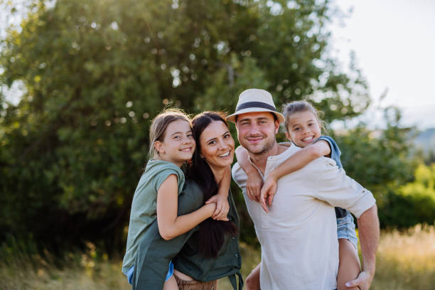 istock Happy family with two small daughters standing outdoors in summer nature. 1419044548