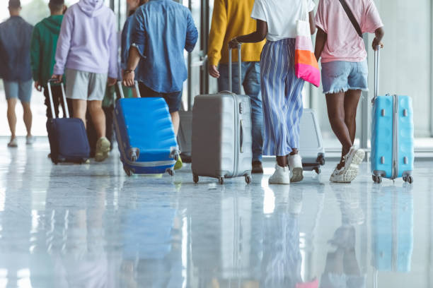 istock Passengers walking with luggage at airport 1419045962