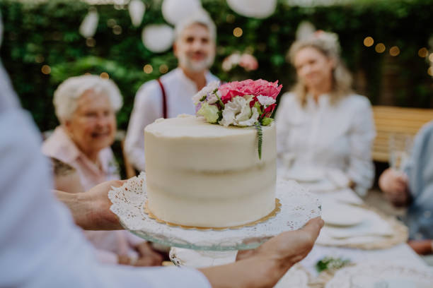istock Mature bride and groom getting a cake at wedding reception outside in the backyard. 1419045975
