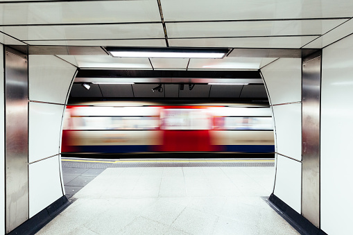 Blurred motion of a subway train as it speeds through one of the stations on the London Underground network.