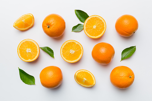 Fruit pattern of fresh orange slices on colored background. Top view. Copy Space. creative summer concept. Half of citrus in minimal flat lay.