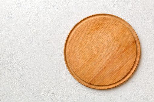 Top view of wooden cutting board on cement background. Empty space for your design.