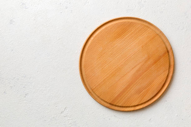 Top view of wooden cutting board on cement background. Empty space for your design stock photo
