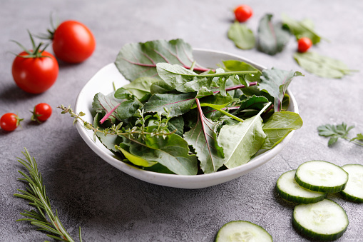 Leaf salad in a bowl with tomatoes and cucumber