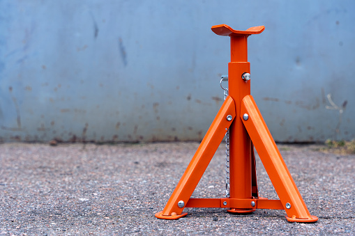 iron Jack stand on concrete floor. protective stand for the jack. Car service, workshop. Repair of cars and engines. Use for lift cars and motorcycles.