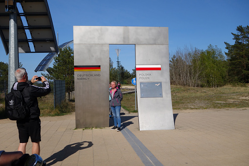 Usedom, Germany, May 9, 2022 - Tourists at the border on the beach promenade between Ahlbeck / Germany and Swinoujscie / Poland, Usedom Island