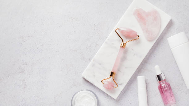 istock Facial roller, gua sha, serum and moisturizing cream on marble background 1419057192