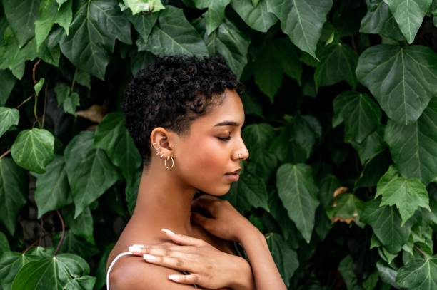 Beautiful young girl posing by the hedge