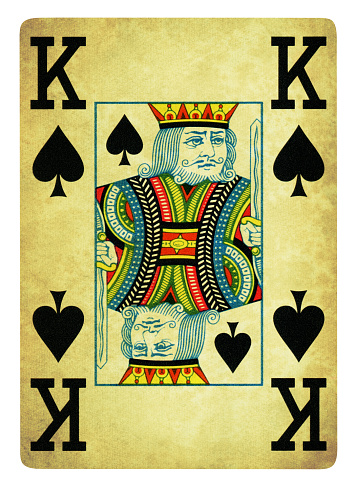 Close-up of a red Joker leaning against a face-down deck of cards on a green baize background