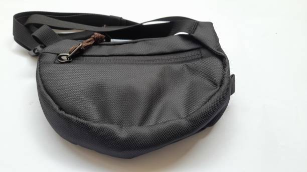 black sling bag seen from above on a white background
