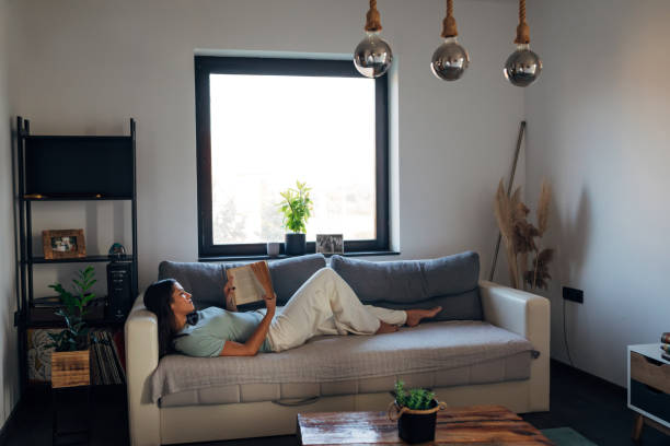 istock Woman taking a break from work, reading a book and lying on a sofa bed 1419065963