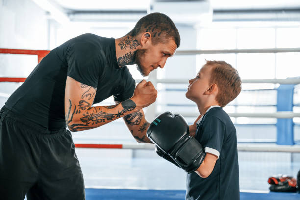 istock Giving advices. Coach is teaching the boy box techniques indoors 1419066779