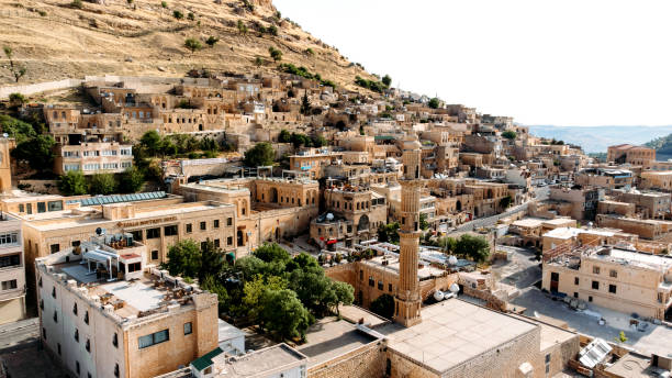 Aerial drone view to the streets of the old city Mardin, Mesopotamia, Turkey Aerial drone view to the streets of the ancient city Mardin, Mesopotamia, Turkey. Mardin cityscape with roofs and minarets in old town midyat photos stock pictures, royalty-free photos & images