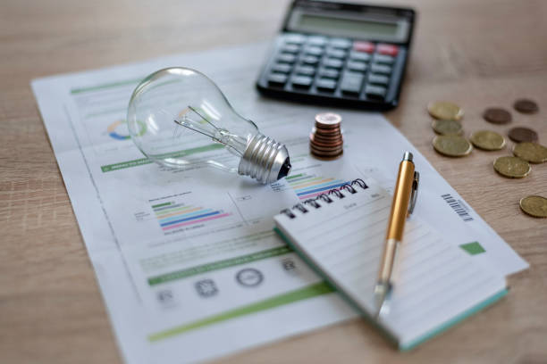 istock light bulb with coins, notebook with a pen and calculator and light bill on a wooden background 1419070856