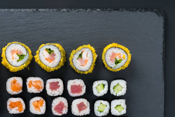 istock close-up, on a black table, top view, assorted Japanese rolls with salmon, tuna, cucumber and tempura 1419070877