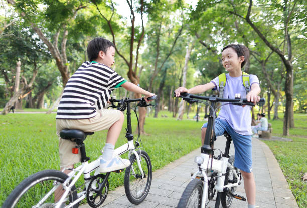 istock Brother riding bikes in city park 1419071565