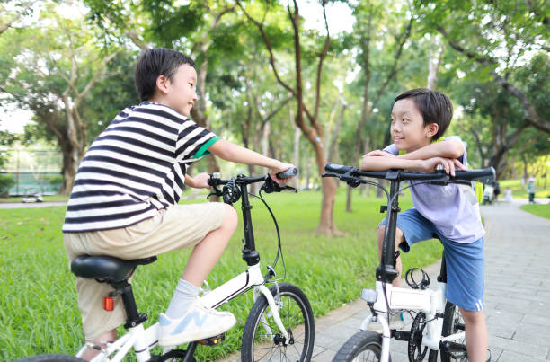 istock Brother riding bikes in city park 1419071580