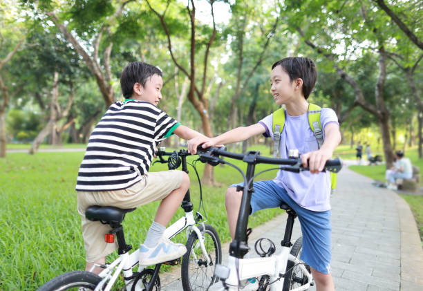 istock Brother riding bikes in city park 1419071583