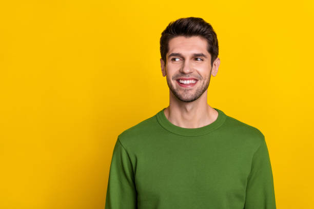 istock Photo of attractive dreamy young guy dressed green pullover looking empty space smiling isolated yellow color background 1419072864