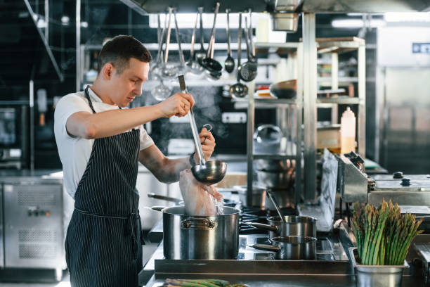 istock Preparing chicken. Chef is on the kitchen making food 1419073252