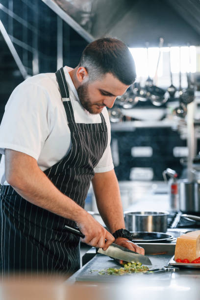 istock Focused on work. Chef is on the kitchen preparing food 1419073283