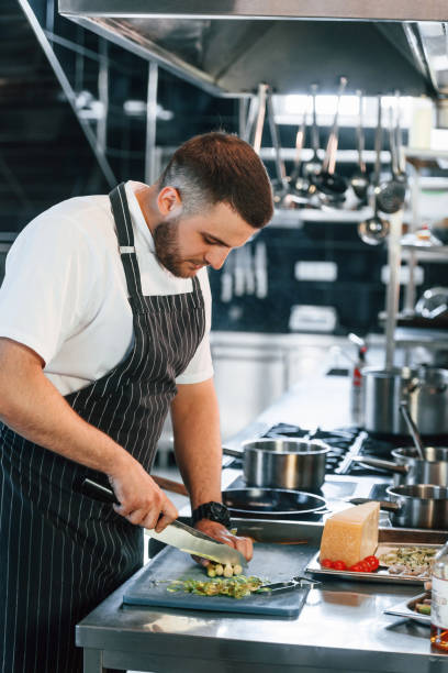 istock Focused on work. Chef is on the kitchen preparing food 1419073286