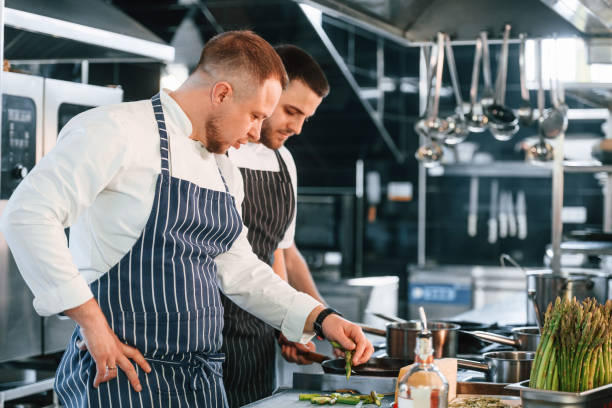 istock Professional employees. Kitchen workers is together preparing the food 1419073946