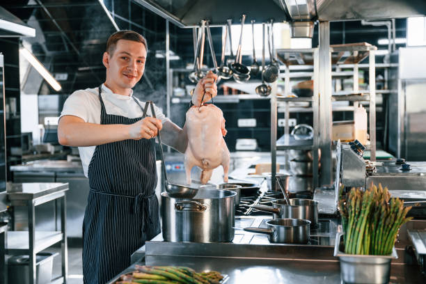 istock Fresh chicken meat. Kitchen workers is together preparing the food 1419075632
