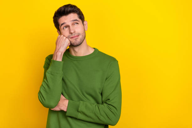 istock Photo of attractive dreamy guy dressed green pullover arm fist cheek looking empty space isolated yellow color background 1419075655