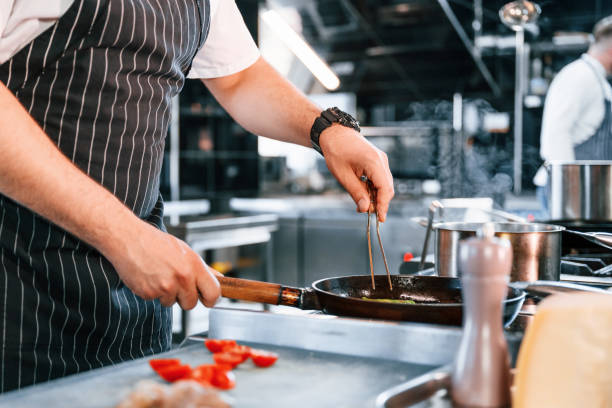 istock Close up view. Slicing ingredients. Chef is on the kitchen preparing food 1419075704